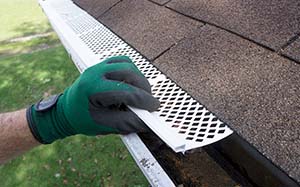 person installing gutter guards sm