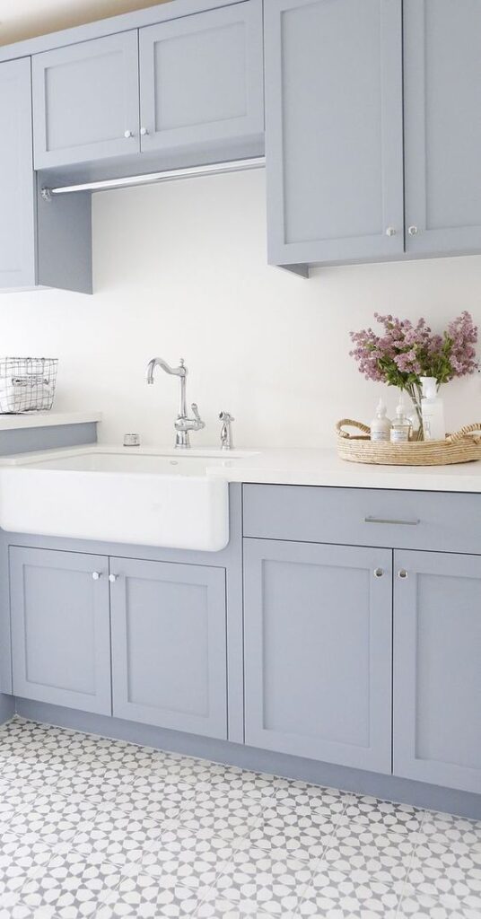 Benjamin Moore New Hope Gray light and airy blue gray paint colors for cabinets in a kitchen pictured here with a farmhouse sink and faucet